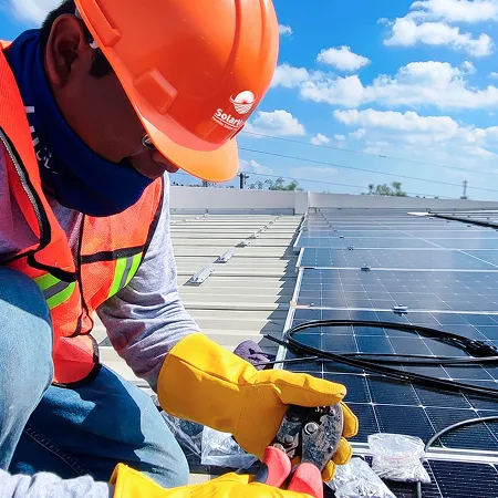 Técnico de Solarver con casco y equipo de seguridad instalando paneles solares sobre una azotea.
