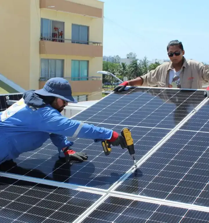 Instalador de Solarver fija un panel a la estructura con un taladro.