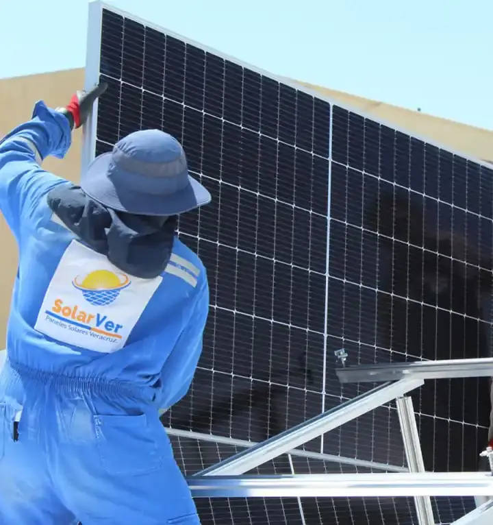 Dos instaladores de Solarver sostienen un panel solar sobre una azotea.