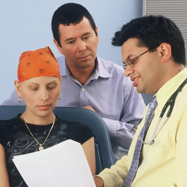 Un médico revisa unos resultados con una paciente joven y un familiar.